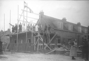 De vlag in top, het dak ging er… op! Naast de woning aan de De Lessepsstraat 80 bouwde woningbouwvereniging Zuilen een werkplaats voor de onderhoudswerkzaamheden. Omstreeks 1925 werd door het bereiken van het hoogste punt de vlag in top gehesen. (En het pannenbier op tafel gezet.)